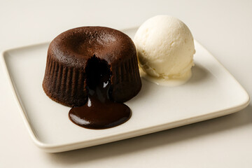 Chocolate lava cake on a square dessert plate with vanilla ice cream