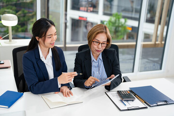 Professional mature business woman manager explaining  solutions helping young employee at work....