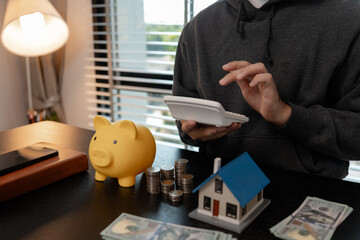 a man is calculating the money from his savings account to buy a house, this man is calculating his...