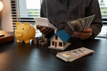 a man is calculating the money from his savings account to buy a house, this man is calculating his...