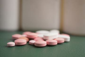 Colorful pills scattered on a green surface