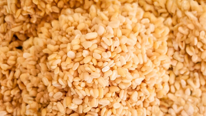 A dense pile of cream-colored peeled mung beans creates a textured food pattern surface