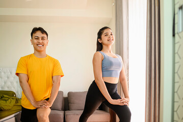Indonesian southeast asian couple stretching before a workout at home for a healthy lifestyle and body care. Fitness and active lifestyles concept