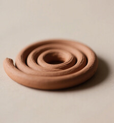 Clay spiral sits on a neutral surface with a circular pattern