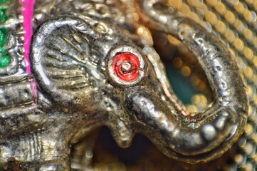 A detailed close-up shot of a silver metal elephant figurine, highlighting its intricate...