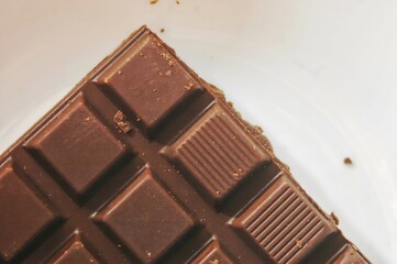 A close-up image of a dark chocolate bar, showcasing its smooth and shiny surface
