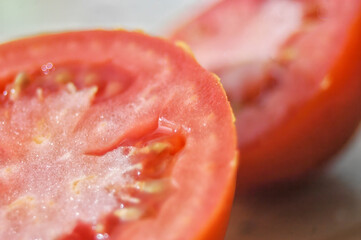 The macro shot highlights the texture and moisture of the tomato