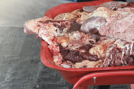 A bunch of fresh mixed meats in a red trolley