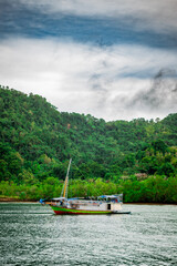 Fishing boats anchored on the beach with mountains in the background