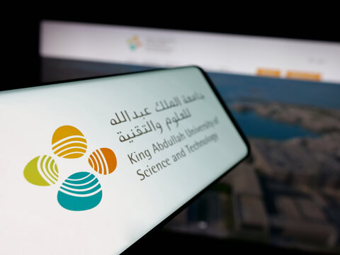 Stuttgart, Germany - 06-14-2025: Smartphone with logo of Saudi King Abdullah University (KAUST) on screen in front of website. Focus on center-left of phone display.