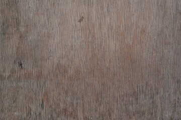 A close-up of a rustic wooden surface with visible grain and natural blemishes, perfect for use as...