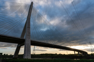 Fototapeta premium Low angle view of Flintshire bridge with power lines running parallel to steel cables supporting structure