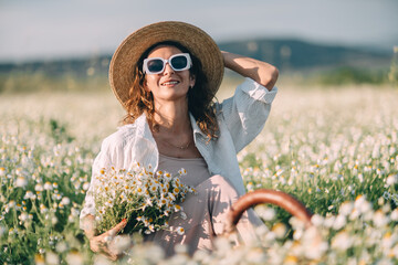 Daisies Woman Summer: Smiling woman with daisies in field enjoys sunny summer day outdoors.