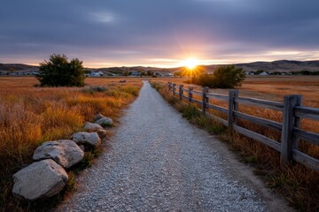 Serene Rural Dirt Road Under Dramatic Sky at Sunrise