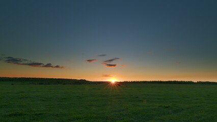 A Stunning Sunset Illuminating the Beautiful Green Field in a Vibrant Countryside Time lapse.