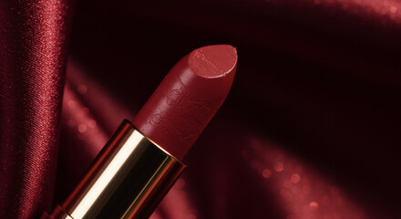 Luxurious Red Lipstick on Rich Burgundy Satin Fabric Close Up Beauty Product Shot