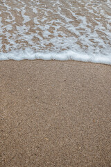 Foam waves on white sand on the beach