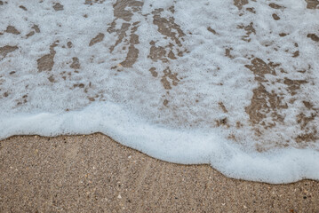 Foam waves on white sand on the beach