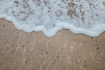 Foam waves on white sand on the beach