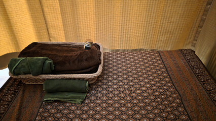 Traditional Thai massage setup with towels and basket
