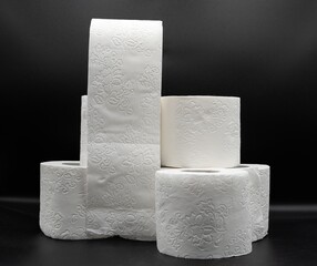 Stack of White Toilet Paper Rolls on Dark Surface – Clean and Minimal Style. Hygiene and Supply...