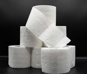 Stack of White Toilet Paper Rolls on Dark Surface – Clean and Minimal Style. Hygiene and Supply...