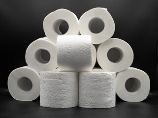 Stack of White Toilet Paper Rolls on Dark Surface – Clean and Minimal Style. Hygiene and Supply...