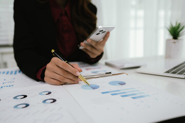 Businessman reviews business infographic on clipboard, analyzing bar and line charts surrounded by...