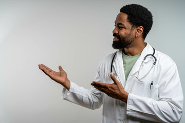 Confident African American doctor showing copy space with hands, smiling