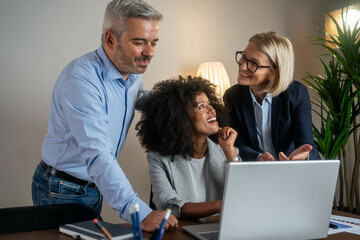 Three busy happy middle aged professional business man and two women executive leaders team using...