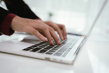 A businesswoman analyzes financial documents with charts and graphs at a desk, highlighting data...