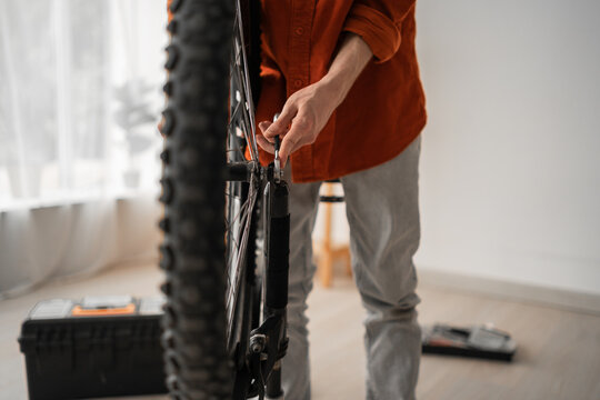 Close-up of male hands adjusting a bike wheel with wrench, performing maintenance - Powered by Adobe