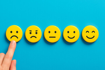 Round wooden icons showing customer facial expressions with disappointed face selected, symbolizing mild dissatisfaction, service critique, and emotional response in user feedback