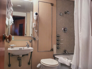 Classic interior design inside bathroom with hair dryer and hooks of cabin stateroom onboard luxury...