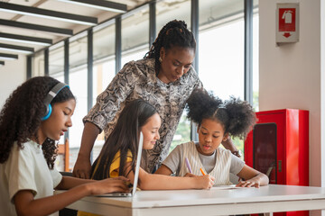 Teacher Guiding Diverse Students in a Modern Classroom, Educator Assisting Children with Schoolwork...
