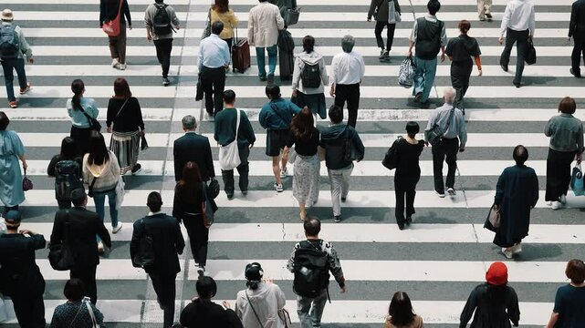 Aerial view of pedestrians walk crossing road intersection junction in downtown. Osaka, Japan.