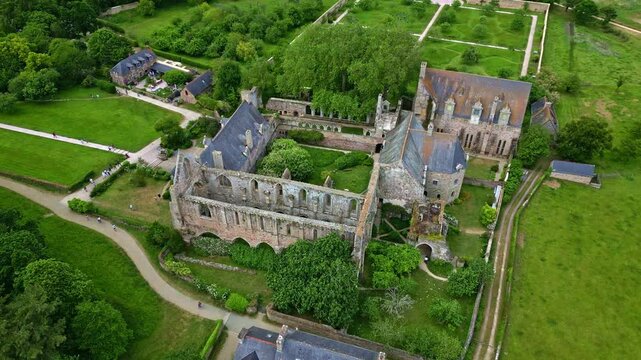 Vertically tilted smooth drone movement around the gothic Abbaye de Beauport historical abbey, Paimpol, Brittany, France.