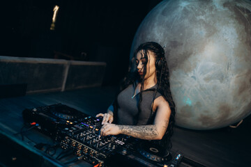 Female DJ Mixing Music on a Modern Setup with a Moonlit Background