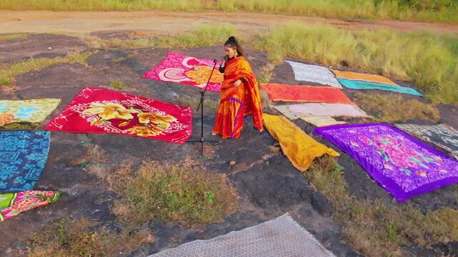 Drone shot sari wear vocalist croon by mic amid vivid cloth
