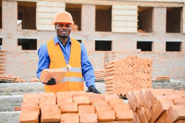 Construction african american worker in uniform and safety equipment have job on building.