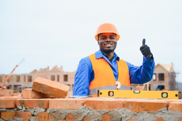 Construction african american worker in uniform and safety equipment have job on building.