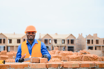 Construction african american worker in uniform and safety equipment have job on building.