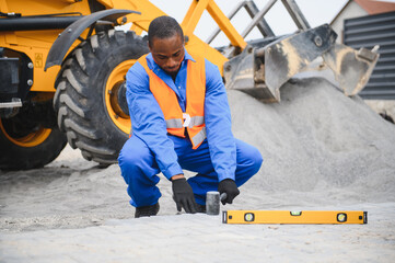 African american master in gloves lays paving stones in layers. Garden brick pathway paving by...