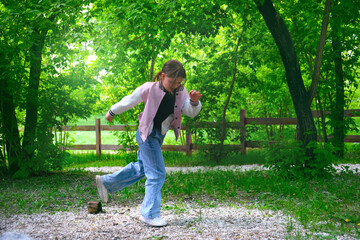 Happy young girl enjoying walking, dancing, jumping. Freedom and carefree. Happy childhood. Activity summer vacations. Lifestyle photography