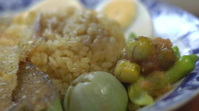 Steamed rice and boiled egg served with fried fish and shrimp paste. Popular food in Thailand.