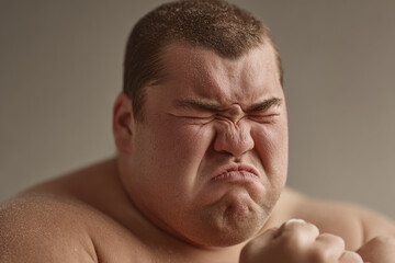 Obraz premium dynamic portrait of japanese sumo wrestler captured in midst of match showing intense emotion