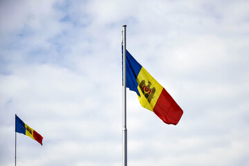 Flags of Moldova on cloudy sky background. Chisinau, Moldova. Copy space. Selective focus.