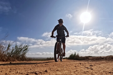 Cyclist Riding the Bike on the Rocky Trail