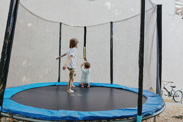 Happy children jumping on a trampoline, enjoying outdoor play in a sunny environment. Perfect for...