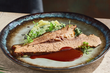 Beef rib brisket with potato spinach mash, rustic ambient lighting, closeup plate composition